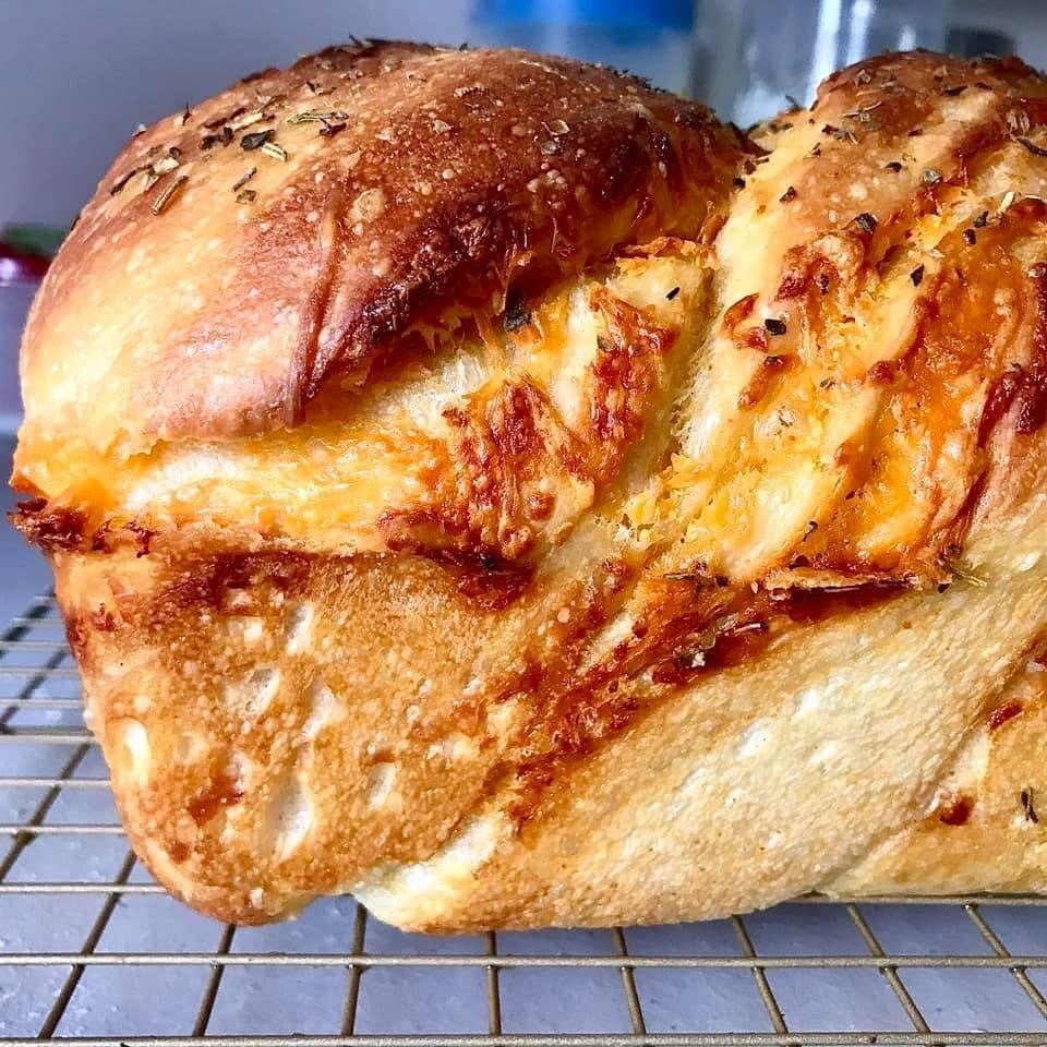 An extreme close-up of a baked sourdough loaf showing its blistered golden crust and open crumb